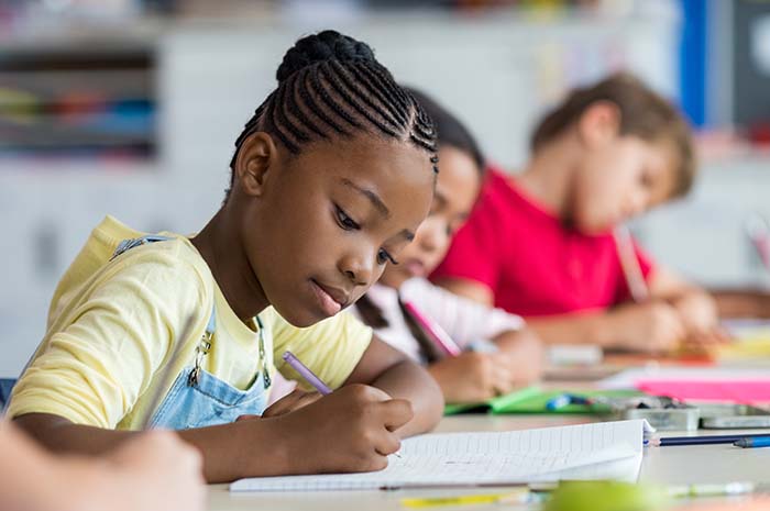Children in classroom writing
