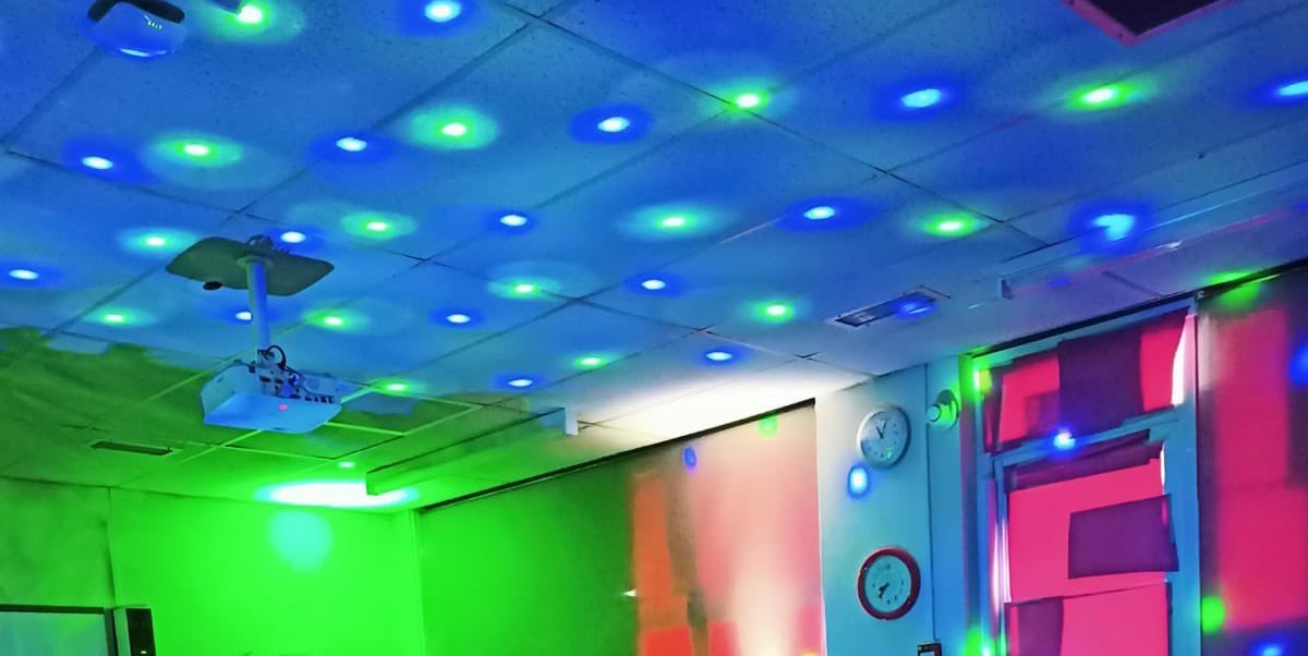 Colour dots of light on the ceiling of a classroom